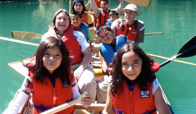 Children and adults in a team canoe on the lake
